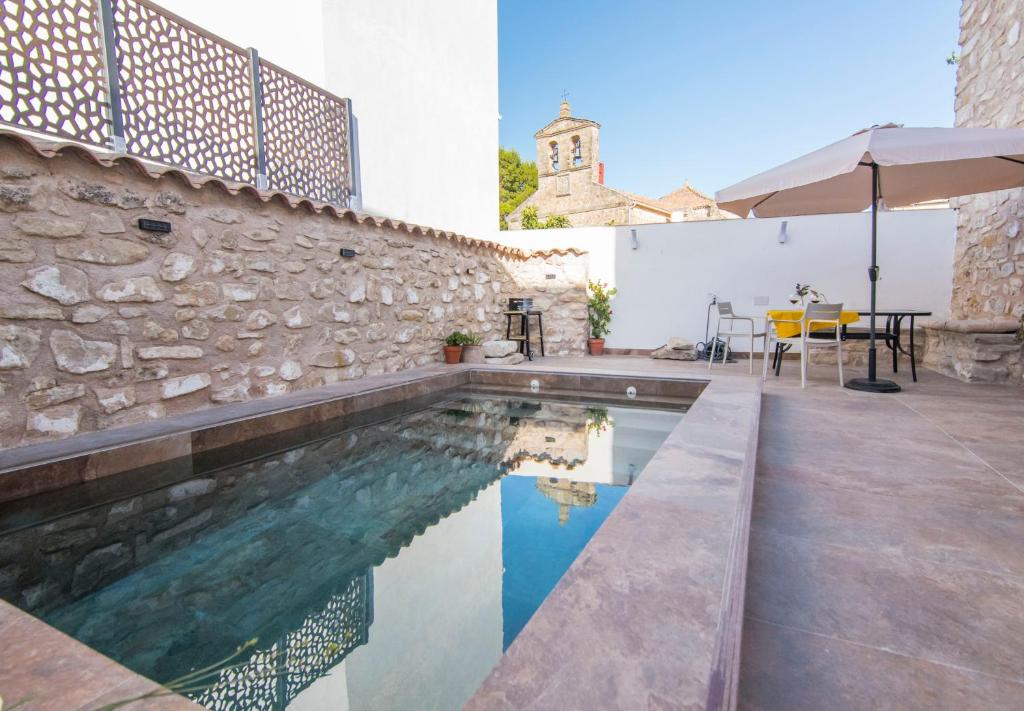 a pool with a table and an umbrella next to a building at El Prado, 2 in El Mármol