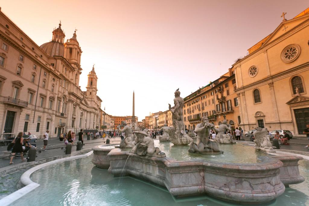 una fuente en medio de una calle con edificios en Vicolo Vecchio 59, en Roma