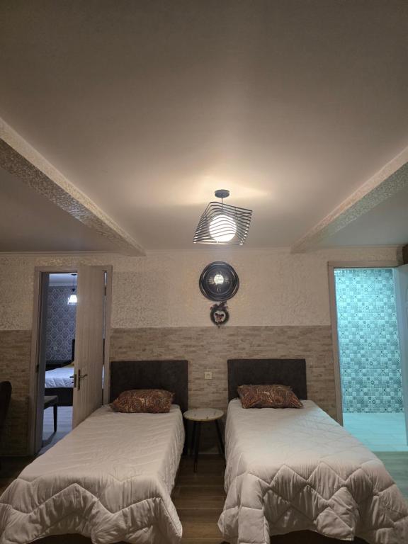 a bedroom with two beds and a light at Guest House KATO in Poti