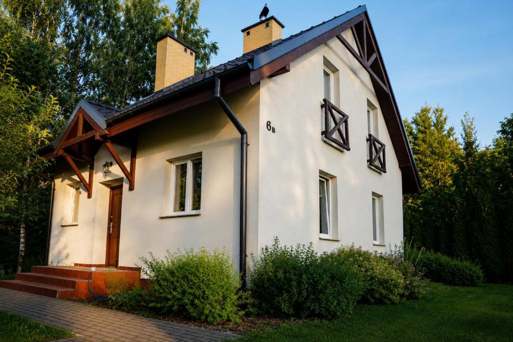 a small white house with a roof at Domek na Morskiej in Jantar