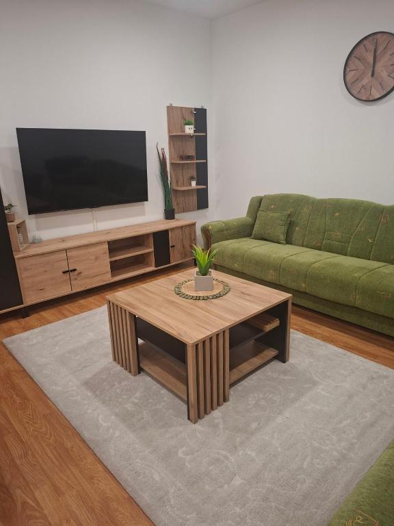 a living room with a green couch and a coffee table at Apartman BECKER in Đakovo