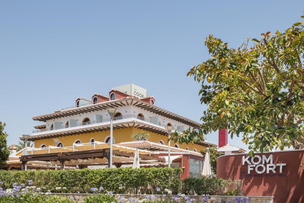 ein großes gelbes Gebäude mit einem Dach in der Unterkunft The Cookbook Hotel & SPA in Calpe
