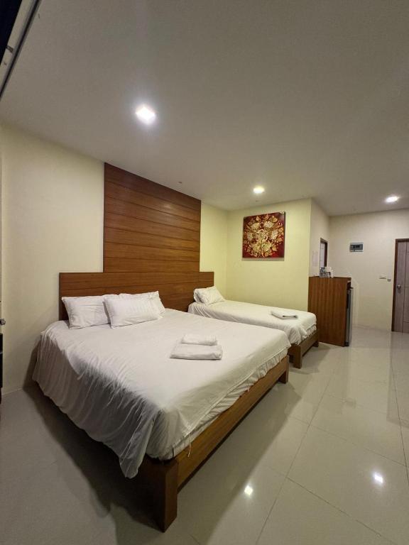 a bedroom with two beds with white sheets at Baan Phu Place in Ban Suan