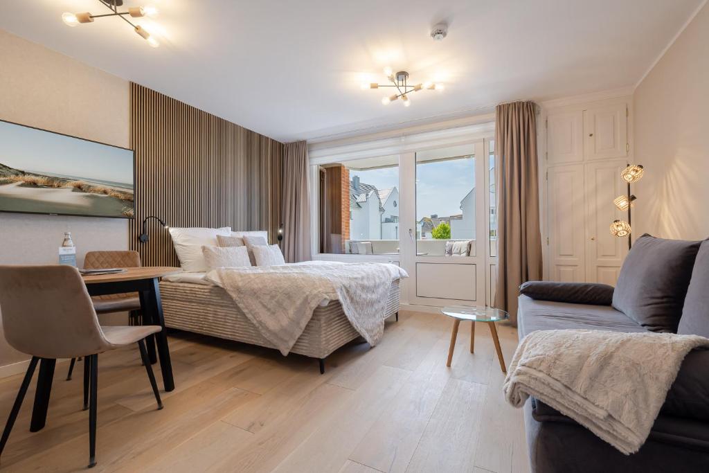 a bedroom with a bed and a table and a couch at Appartement Agnes in Westerland