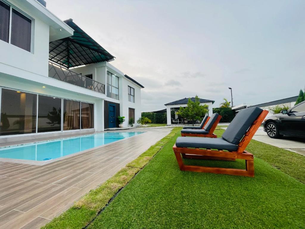 a house with a swimming pool and two lounge chairs at Villa renacer 1 in Baní