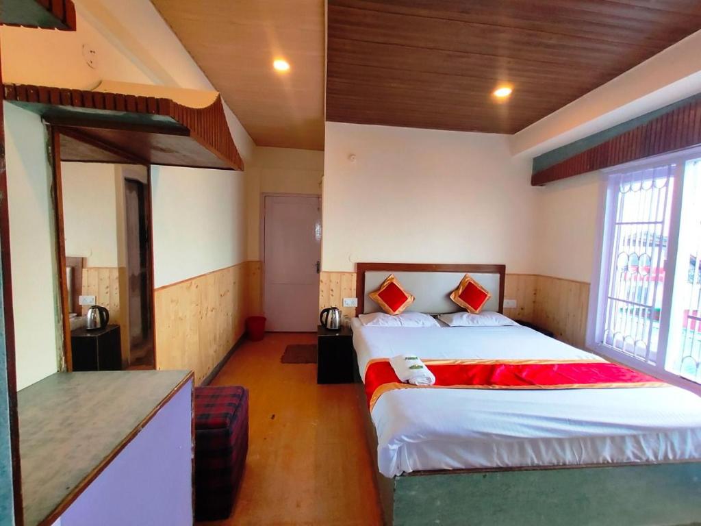 a bedroom with a bed and a kitchen in a room at Regency Shooryaa Near The Mall Shimla in Shimla