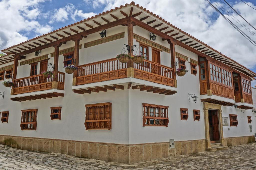 una casa con balcones de madera en una calle en Hotel Campanario Real, en Villa de Leyva