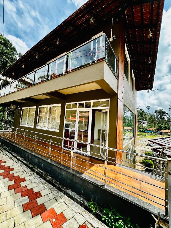 a building with a balcony on top of it at Satkar Comforts in Attigundi
