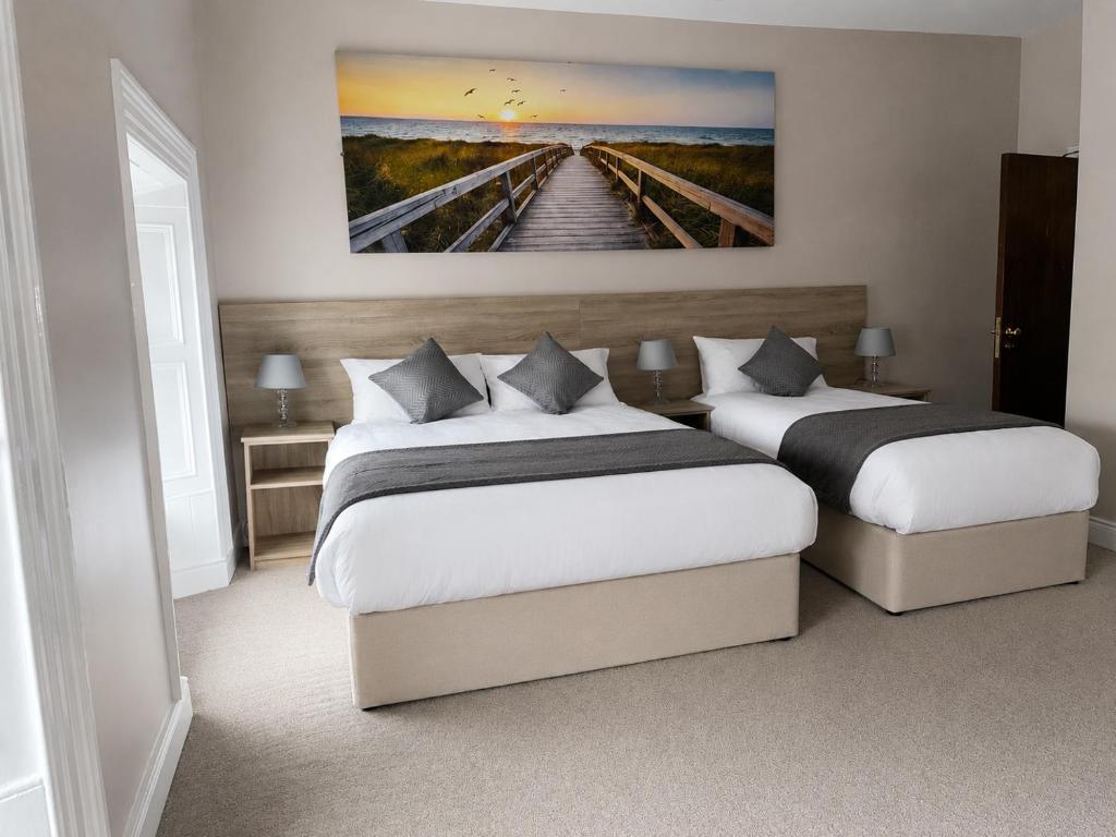 a bedroom with two beds and a painting on the wall at Grove house Dunleer in Dún Léire