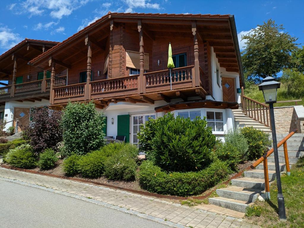 a large wooden house with a balcony at Golfsuite Axel in Uttlau-Haarbach in Haarbach