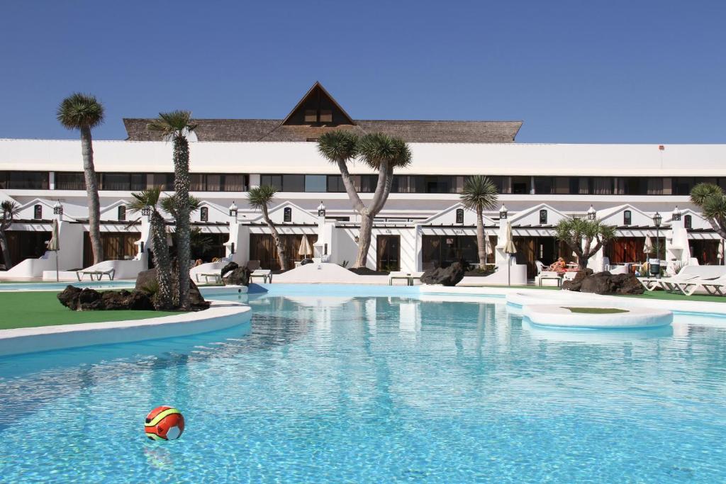 a pool at a resort with a ball in the water at Sands Beach Resort in Costa Teguise