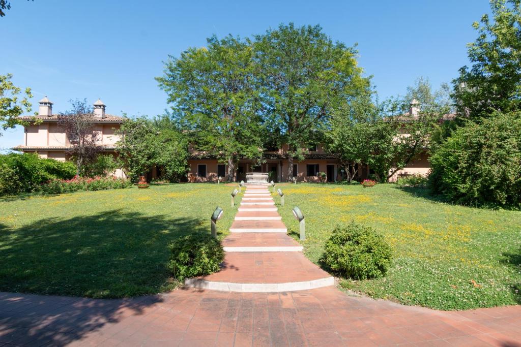 a path in a park with a house in the background at Villa G in Ravenna