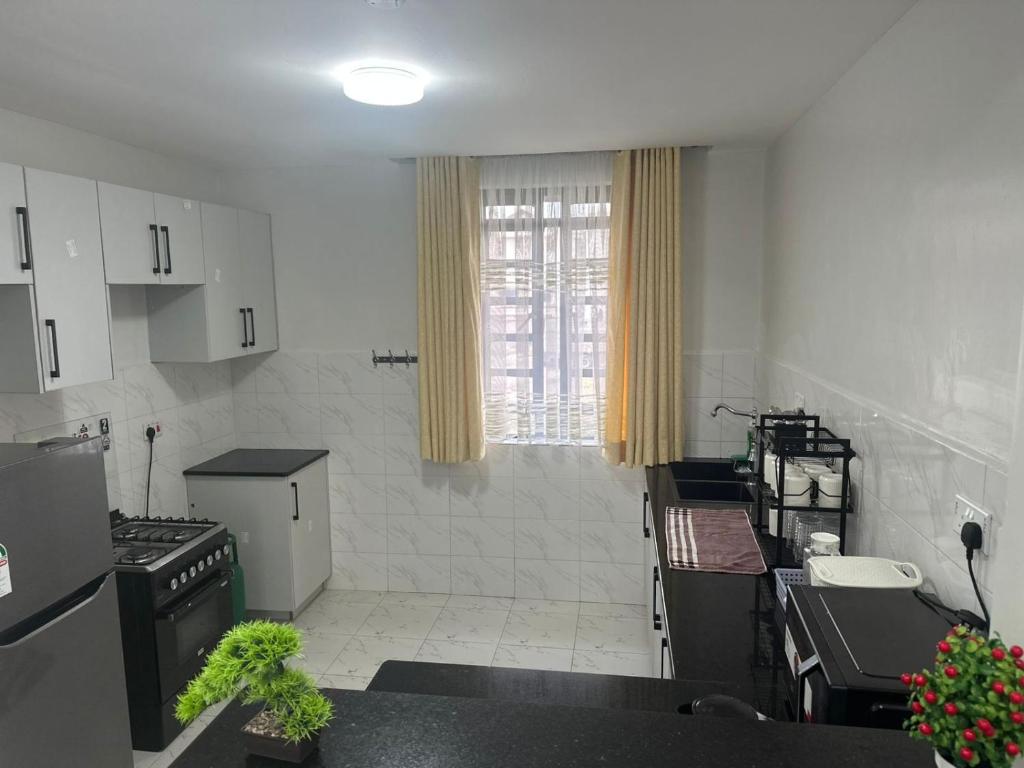 a kitchen with white appliances and a window in it at Nalim bliss garden in Ruiru