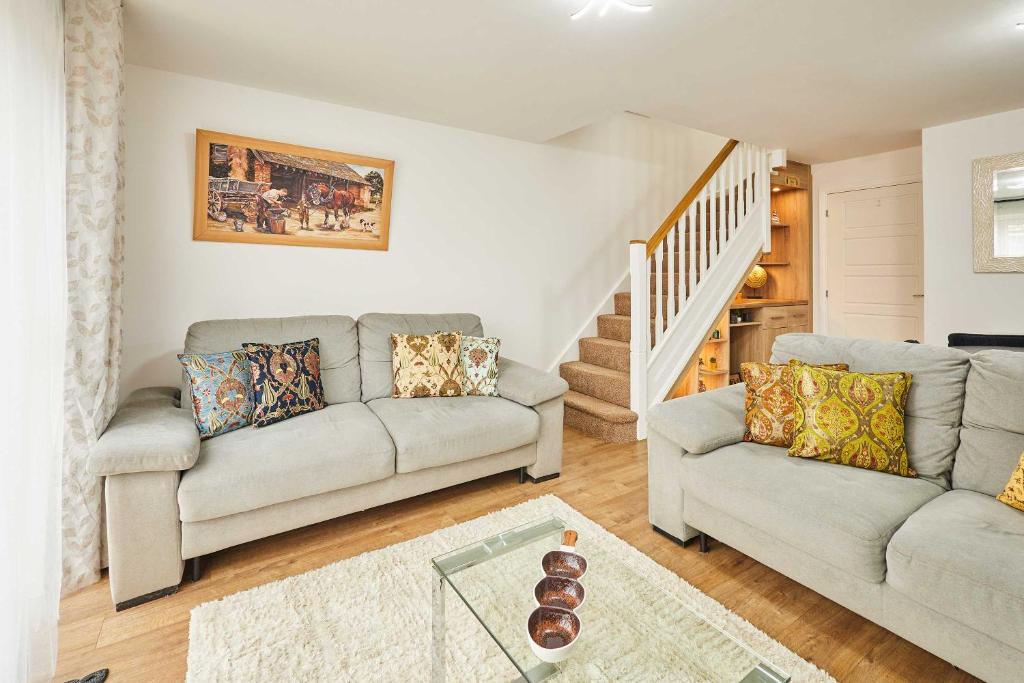a living room with two couches and a staircase at Host & Stay - Fells Paddock in Bedford