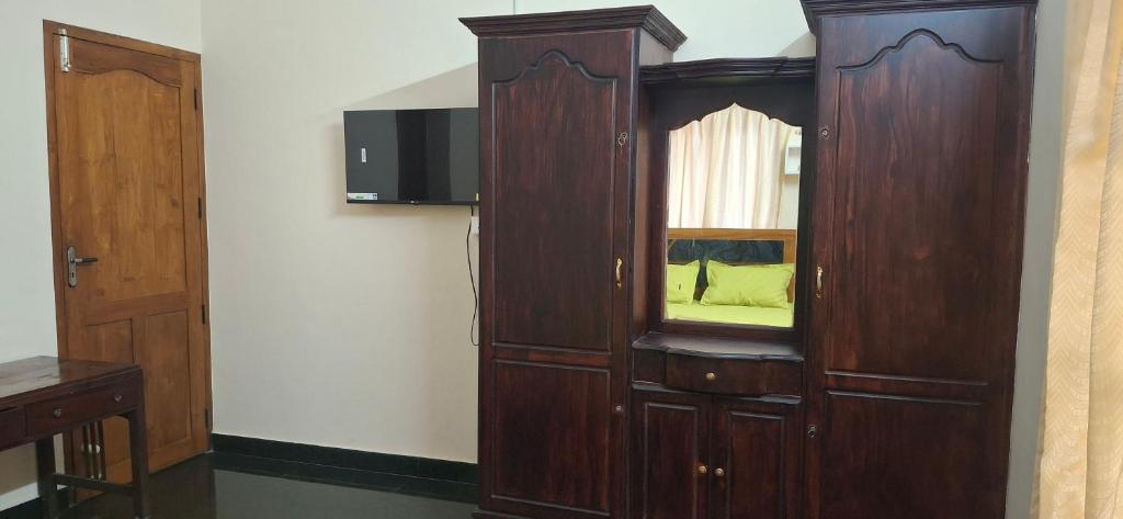 a large wooden cabinet with a window in a room at Smiley Homestay in Varkala