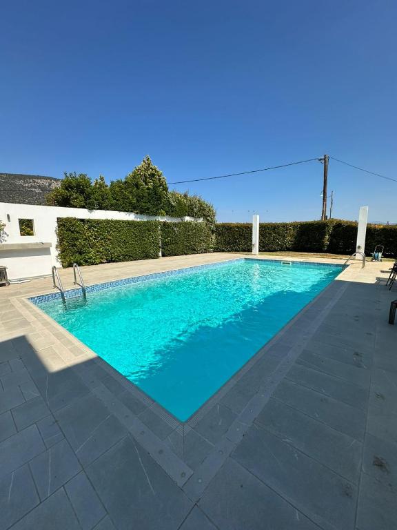 a swimming pool with blue water in a yard at Coastal Pool Hideaway in Loukísia