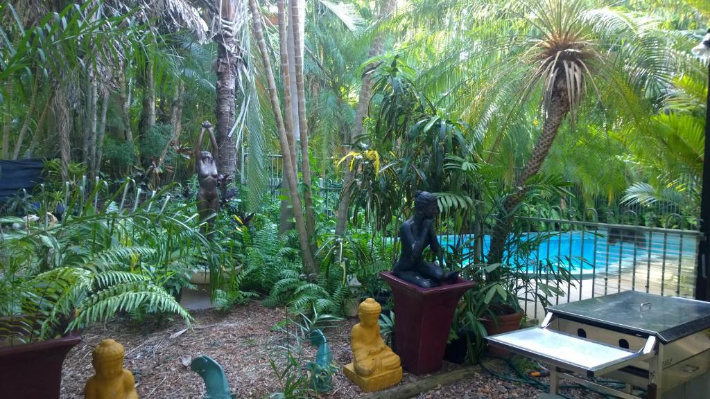 a garden with a statue in front of a pool at Palmerston Sunset Retreat in Palmerston