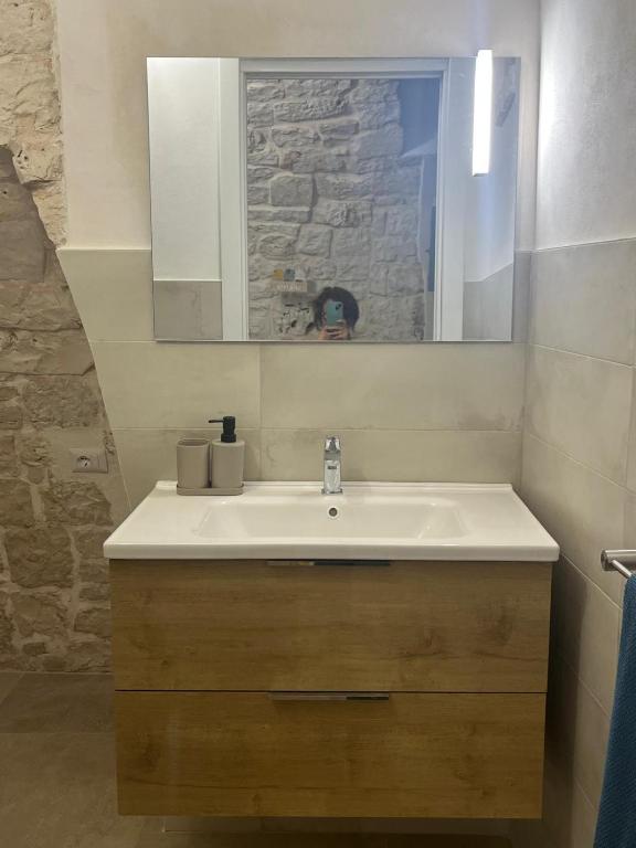 a bathroom with a white sink and a mirror at La casetta di Franci in Castellana Grotte