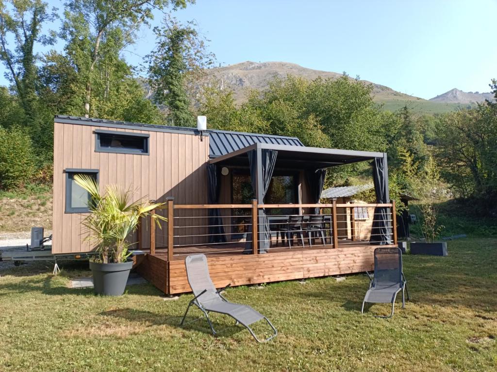 a tiny house with two chairs in the yard at Tiny house chalet montagnard in Arcizans-Dessus