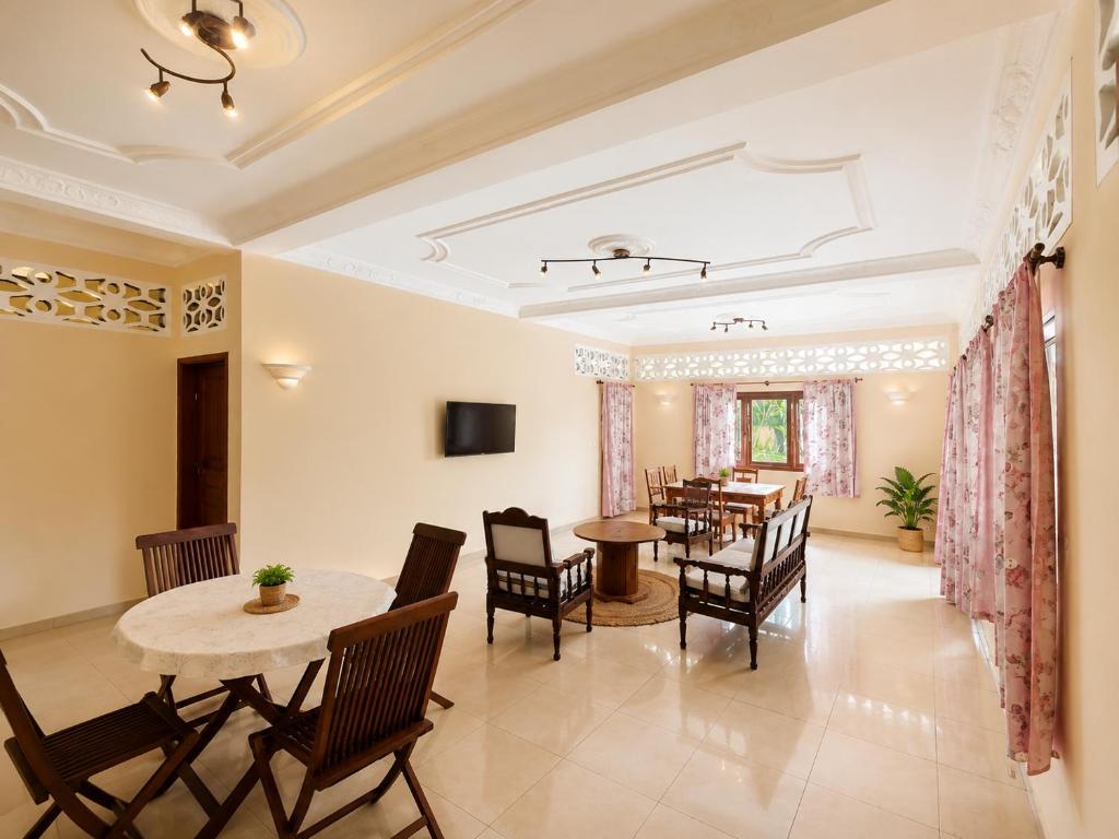 a dining room with a table and chairs at Appartement Baie-Rose SP Nosy-Be in Nosy Be