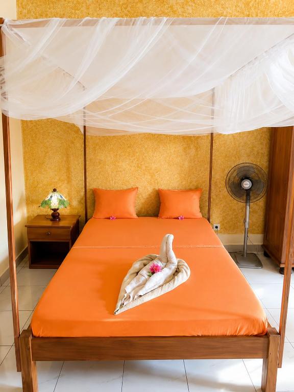 a bedroom with an orange bed with a swan on it at Studio Ylang - Vue mer & détente à Nosy Be in Nosy Be