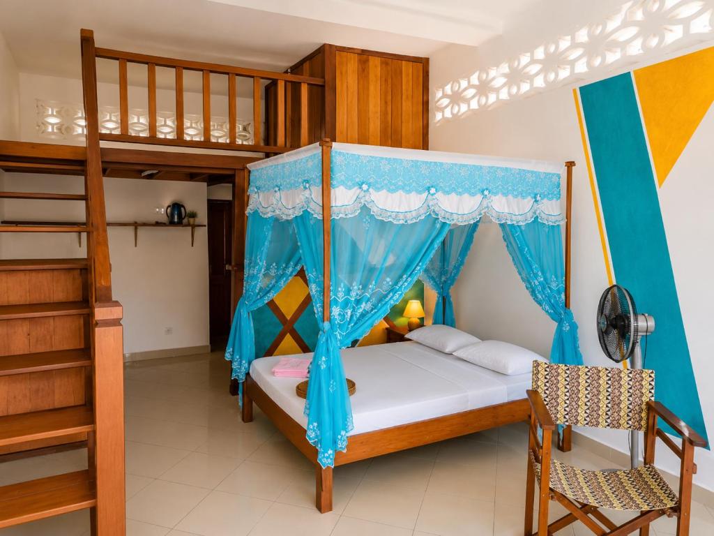 a bedroom with a bunk bed and a ladder at Studio Cannelle - À deux pas de la plage Nosy Be in Nosy Be