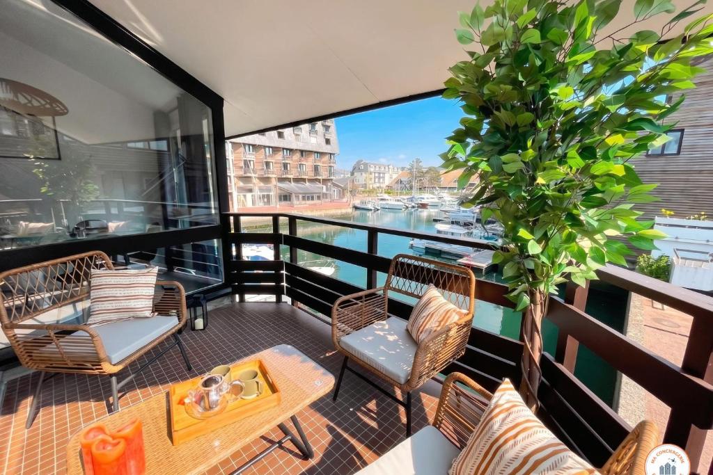 a balcony with chairs and a table and a plant at Temps des Cerises - Terrasse - Plage - Marina in Deauville