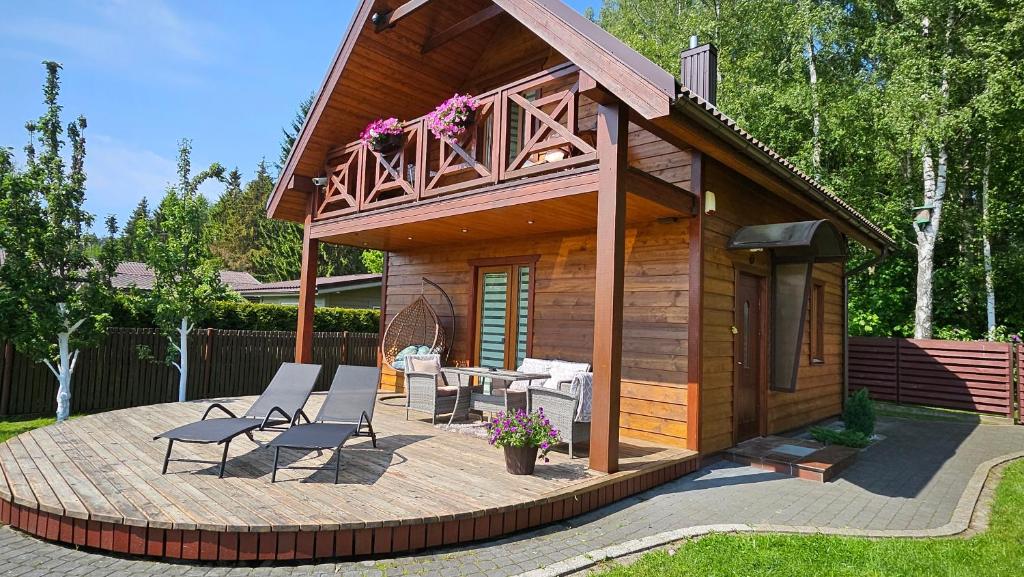 a small cabin with a deck and a patio at Namelio-mini vilos nuoma in Palanga