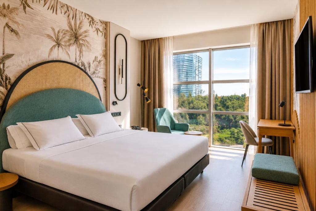 a hotel room with a bed and a large window at Vincci Maritimo in Barcelona