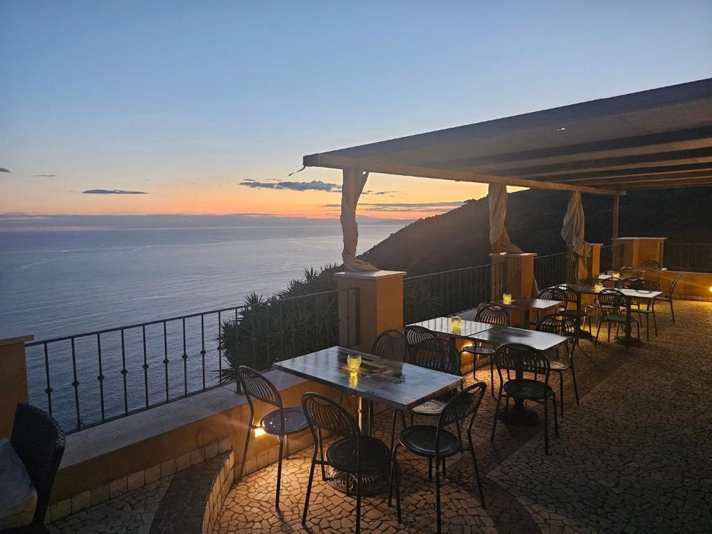 a group of tables and chairs on a balcony with the ocean at Il Borgo Di Campi in Riomaggiore