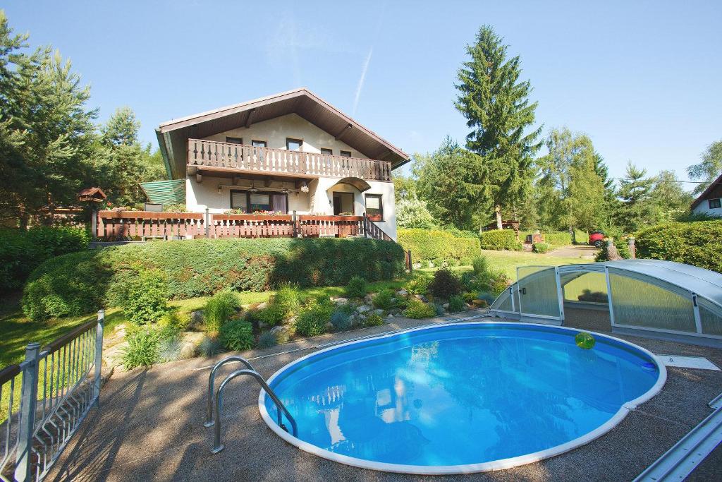 a house with a large swimming pool in front of it at Chata Ostrov - Eiland v srdci Českého Švýcarska in Tisá