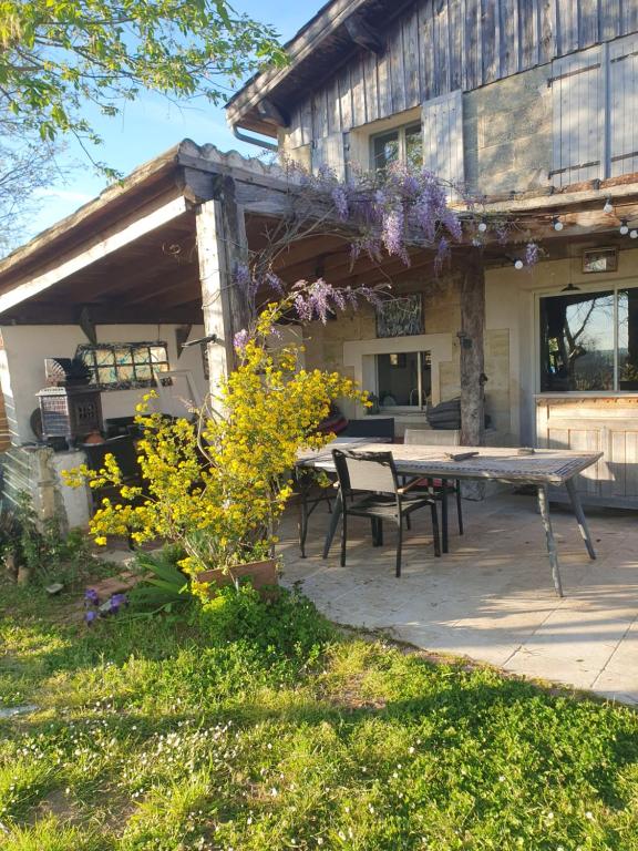 a patio with a picnic table in front of a house at Au Vélo dans l'Arbre in Saint-Sulpice-de-Faleyrens