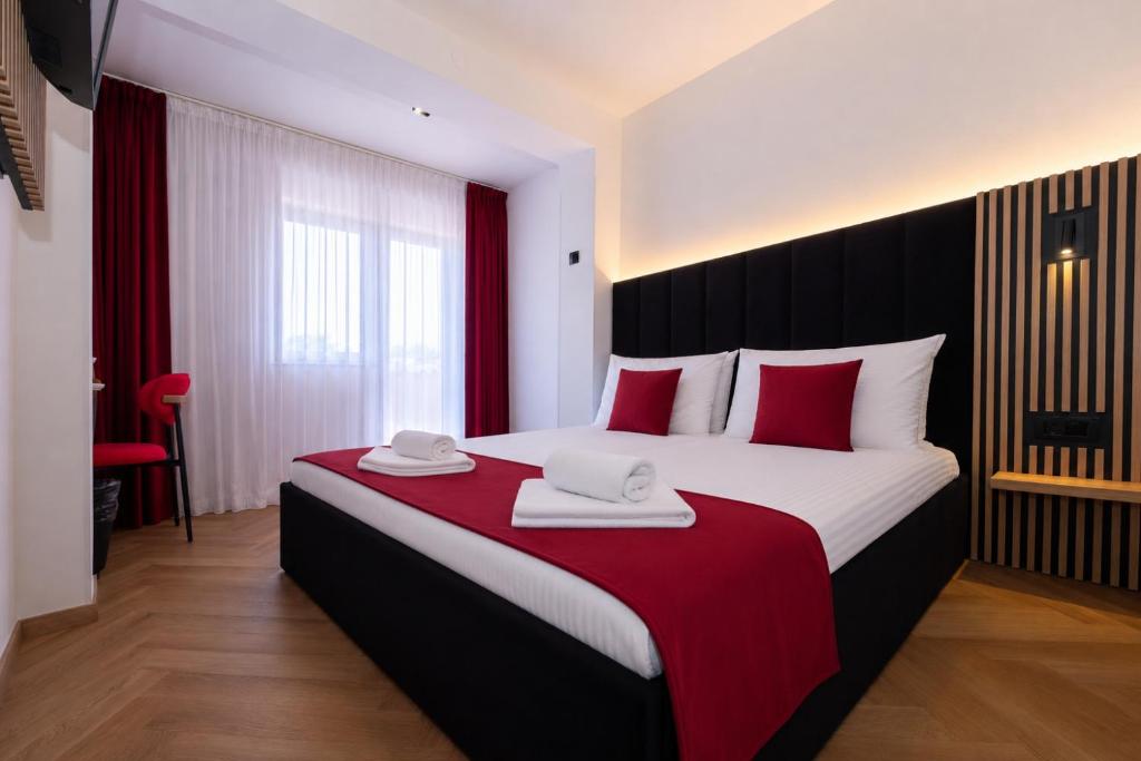 a bedroom with a large bed with red and white pillows at Sto Rija in Krk