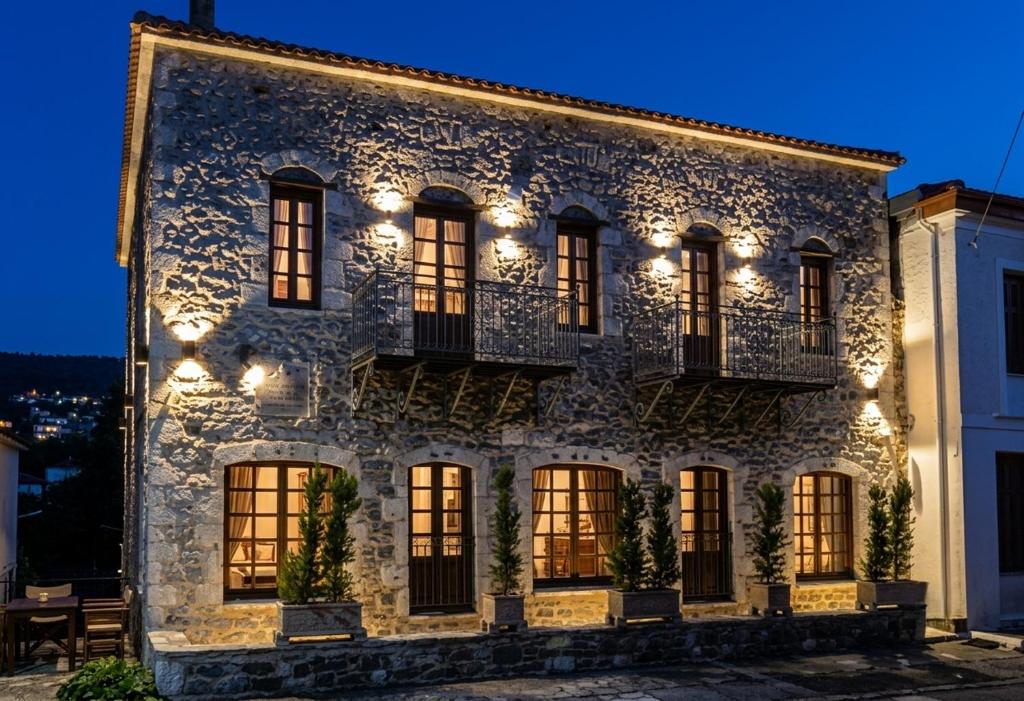 a stone house with lights on it at night at Archontiko Leontari in Leondari