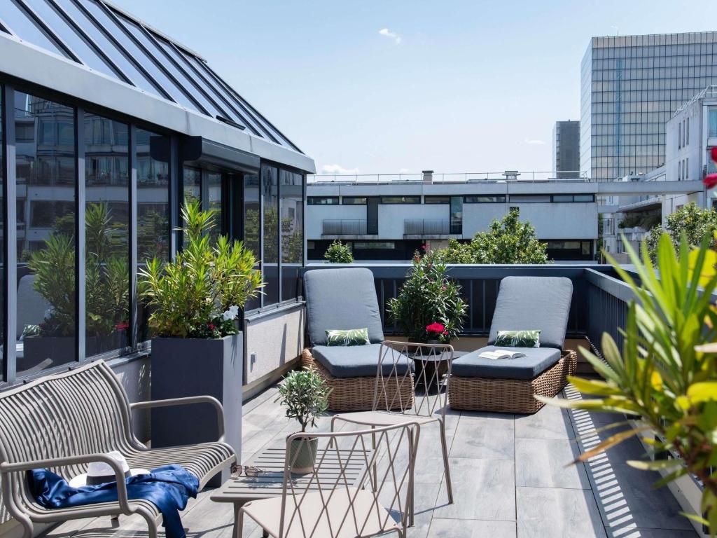 a balcony with chairs and plants on a building at Mercure Paris Bercy Bibliothèque in Paris
