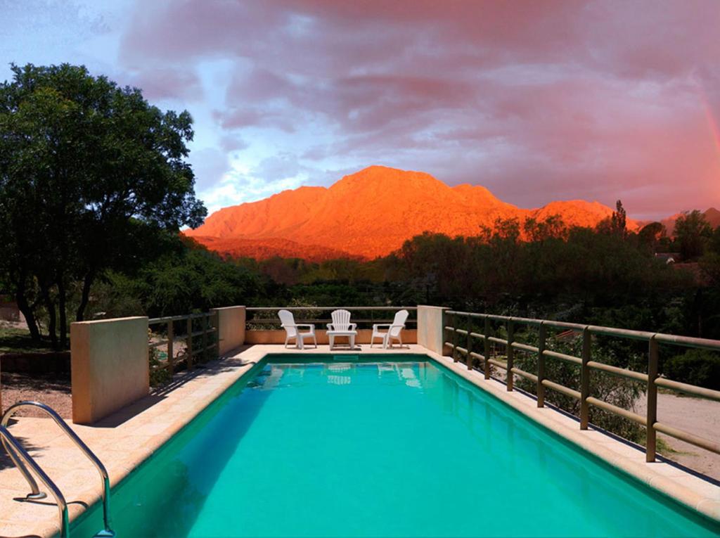 una piscina con 2 sillas y una montaña en Aguas Claras en Capilla del Monte