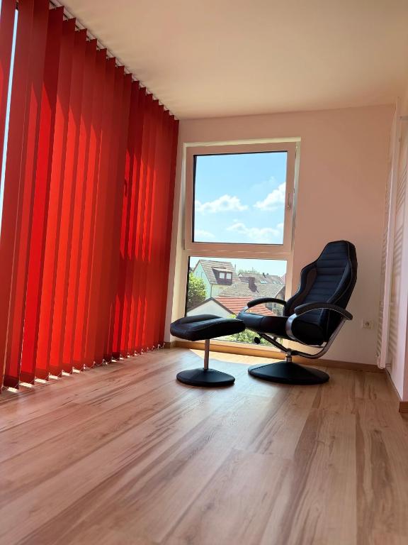 a room with red curtains and two chairs in front of a window at Modern Apartment 2 Graf - New!! in Grafenwöhr