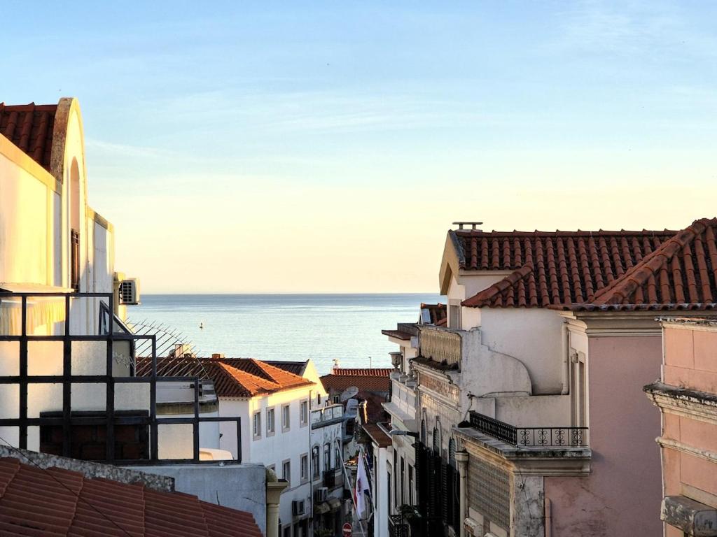 a view of roofs of buildings and the ocean at Casa do Mar & Sesimbra Center View in Sesimbra