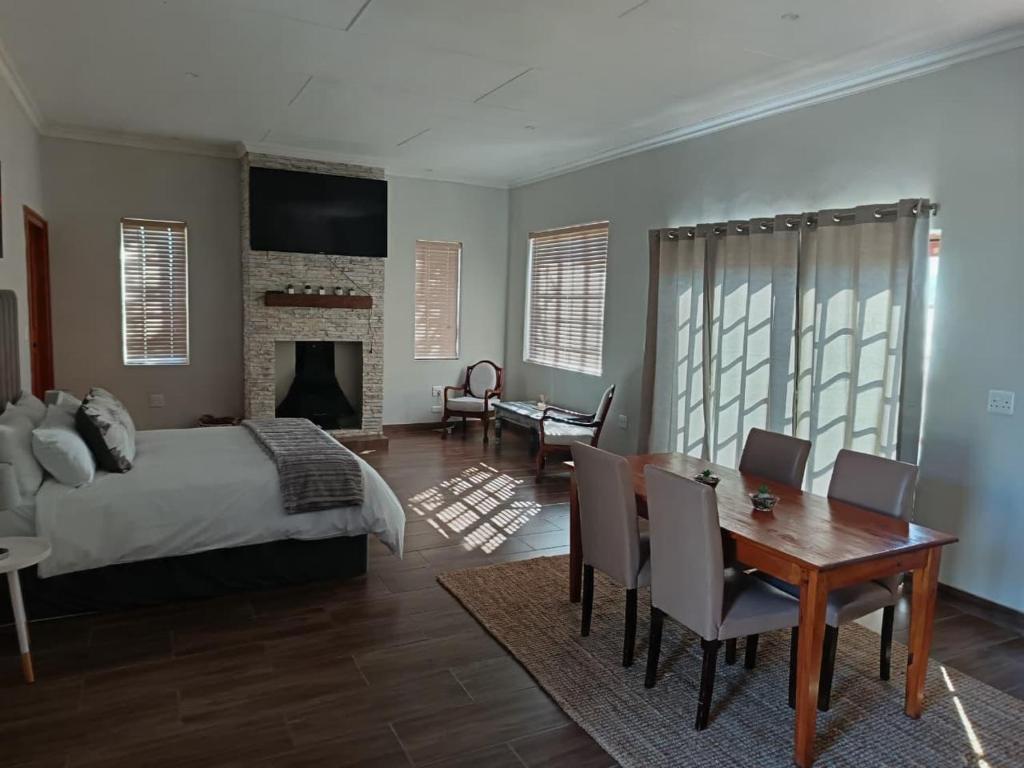 a bedroom with a bed and a table and chairs at Cape Karoo Lodge in Riversdale