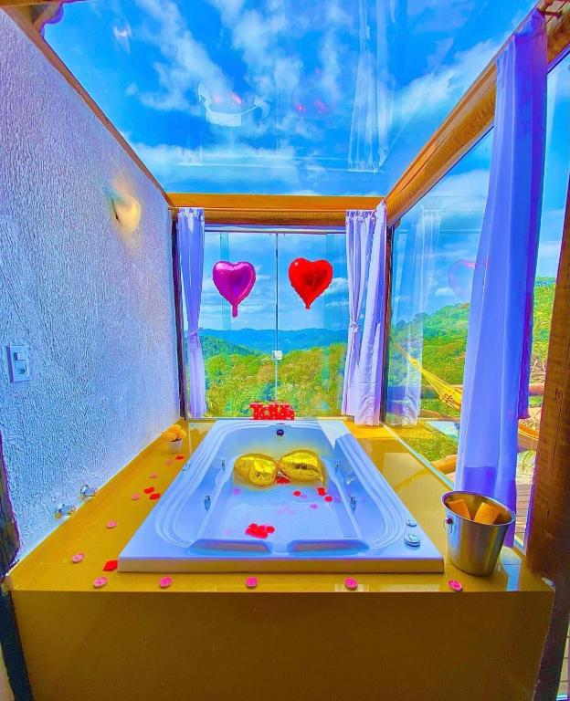 a bath tub in a room with a window at Sítio Emanoel Bangalôs in Domingos Martins