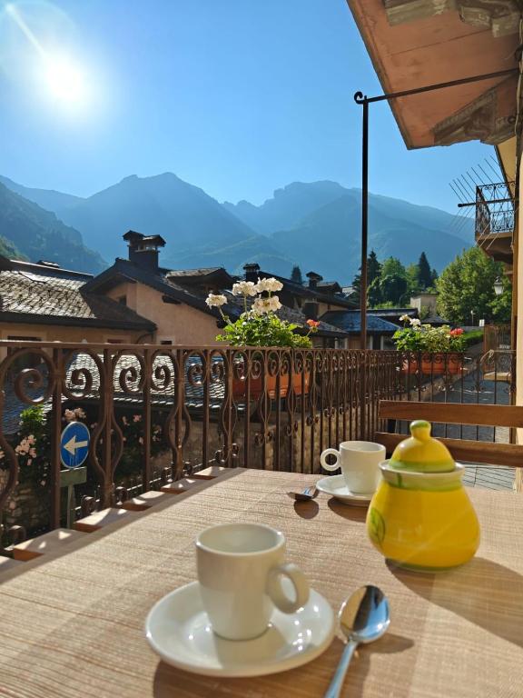 a table with cups and saucers on a balcony at Casa dello sciatore in Limone Piemonte