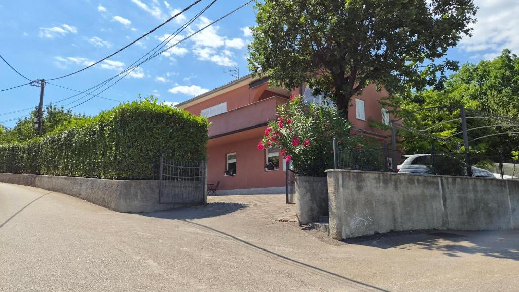 a house with a fence in front of it at Apartman ENA in Opatija