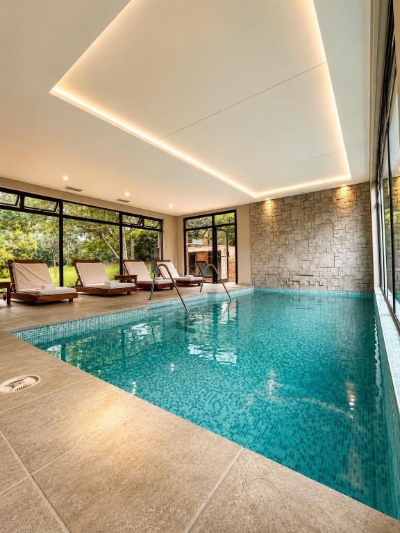 a swimming pool in a house with windows at Paradiso Hotel & Spa in Merlo