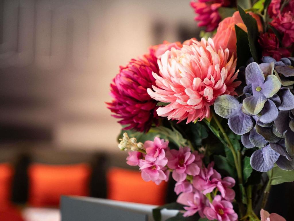 a vase filled with pink and purple flowers at ibis Saint-Denis Stade Ouest in Saint-Denis