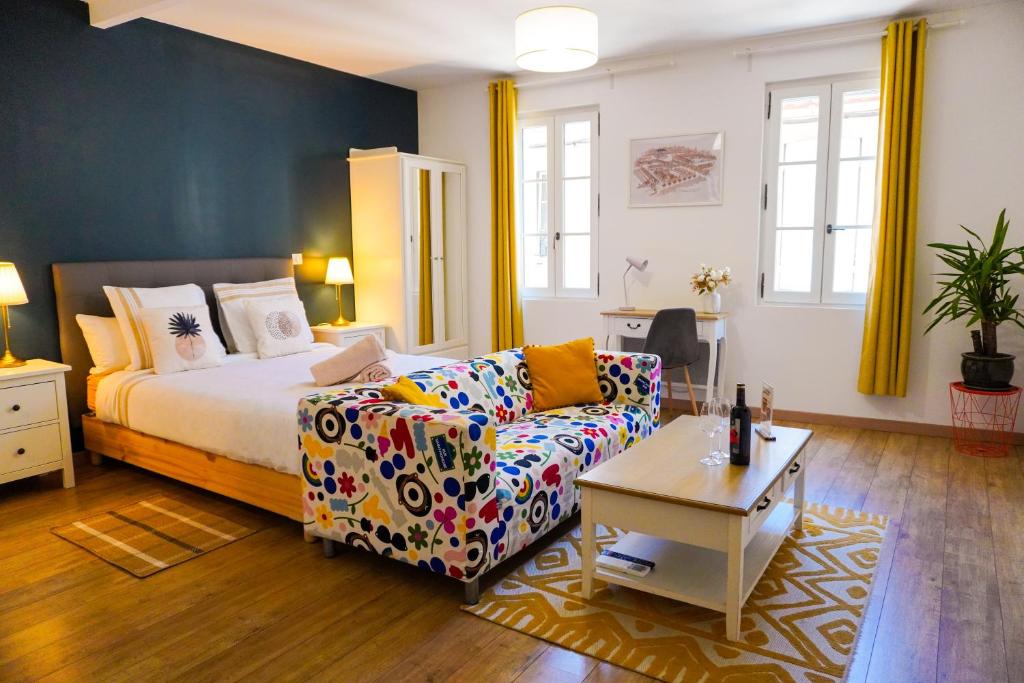 a living room with a bed and a couch at Hôtes de Saint-Emilion II in Saint-Émilion