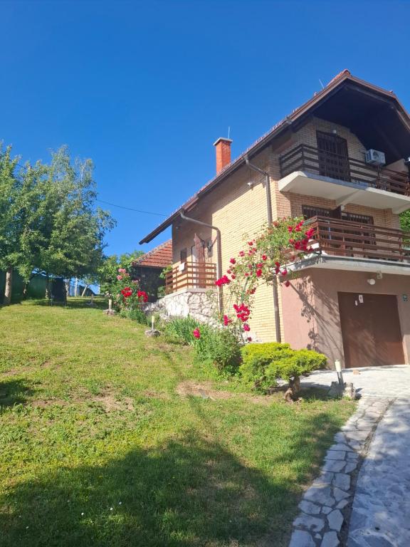 a house with flowers on the side of it at Holiday house Šadrvan Sarajevo in Hadžići