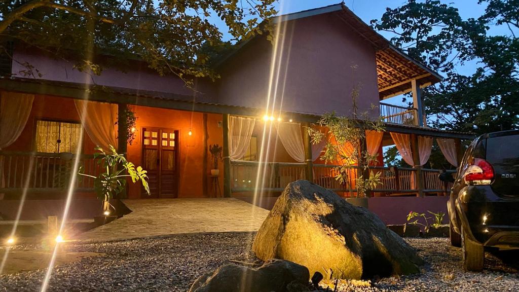 a house with a large rock in front of it at Pousada Refugio da Ilha Ilhabela in Ilhabela