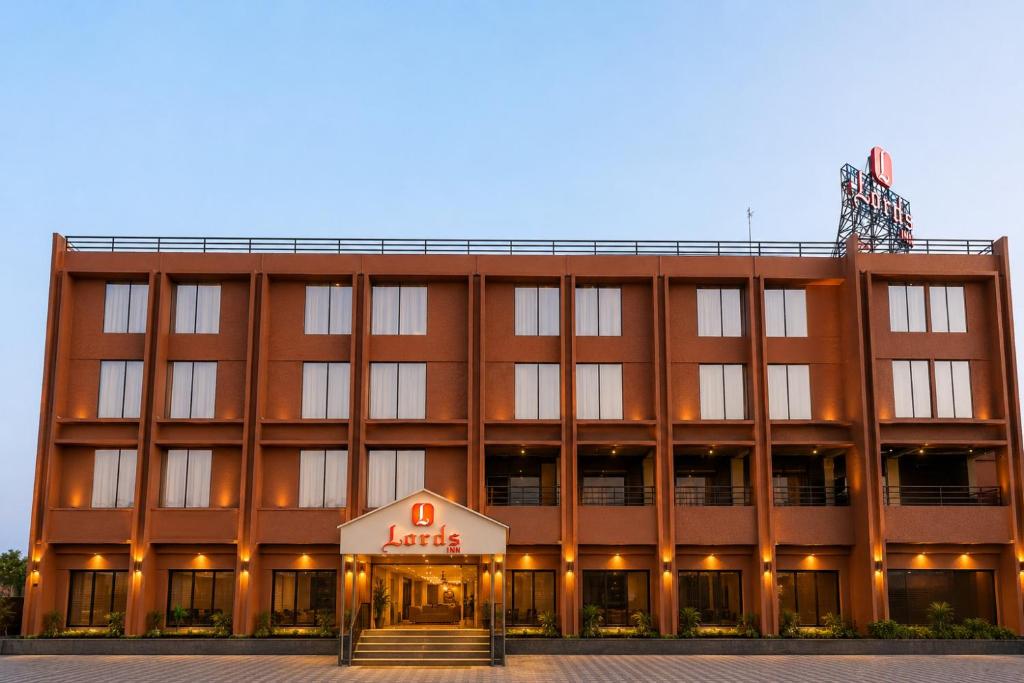 a large building with a hotel sign in front of it at Lords Inn Sanand in Chharodi