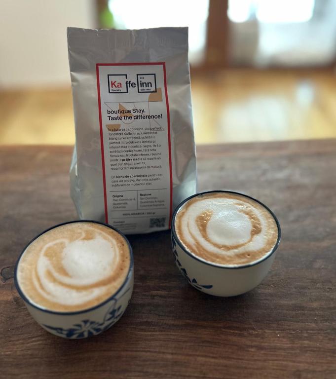 two cups of coffee sitting on top of a table at Kaffeinn Specialty Coffee Baile 1 Mai in Baile Unu Mai