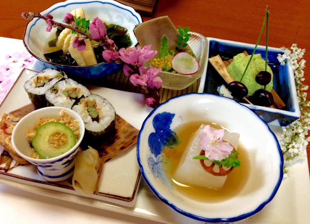 a tray with a plate of sushi and a bowl of soup at Minshuku Ryokan Kawai in Shinshiro